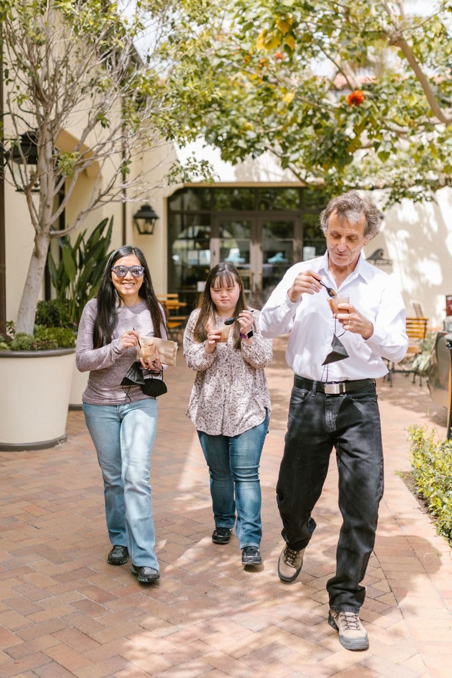 A young woman with Down syndrome walking through town with two companions